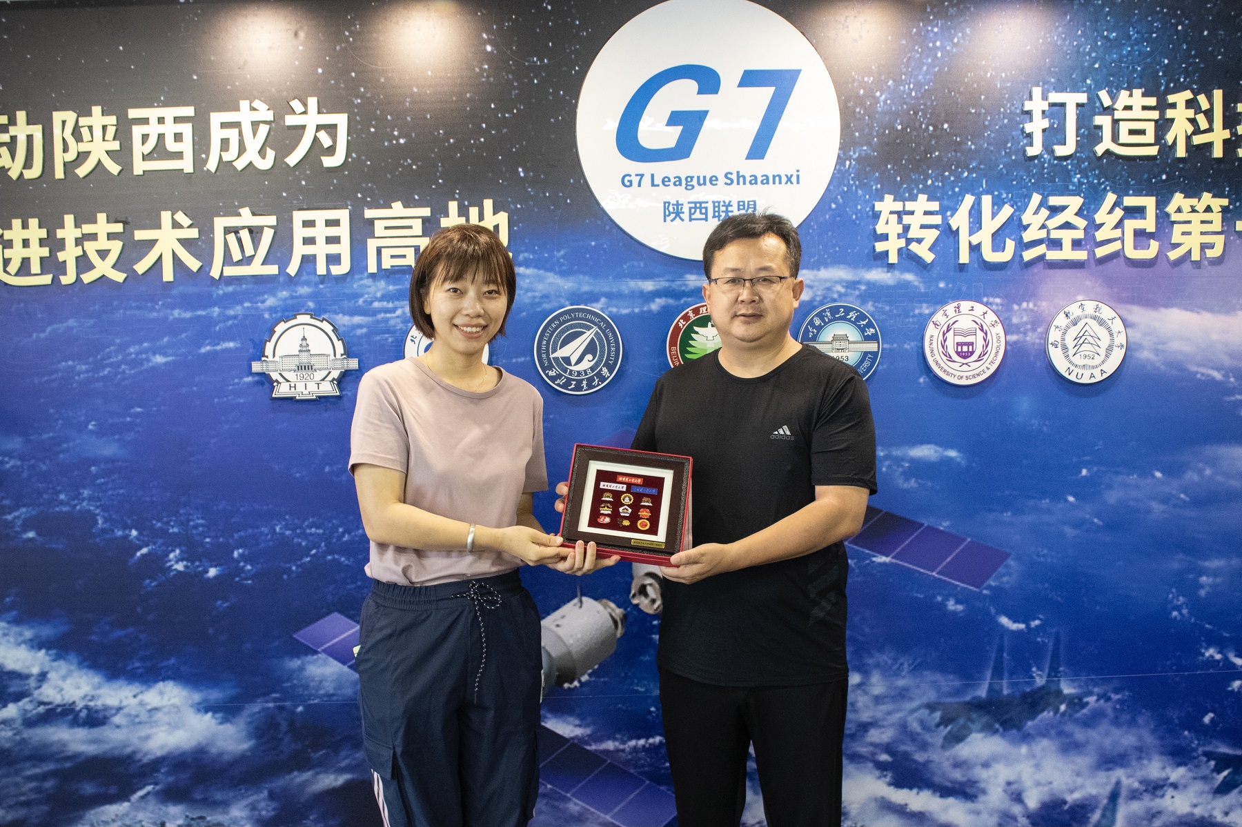 1631089523147036264.jpg 图十七 吕俊宏老师代表实践团向陕西校友会代表杨小勇会长赠送礼物.jpg