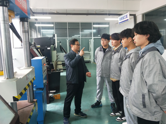 张仲欣教授给学生介绍钢板冲压成型机的使用.jpg